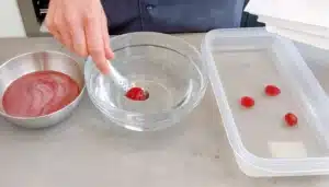 un bol con agua aclarando esferificaciones de cocina molecular