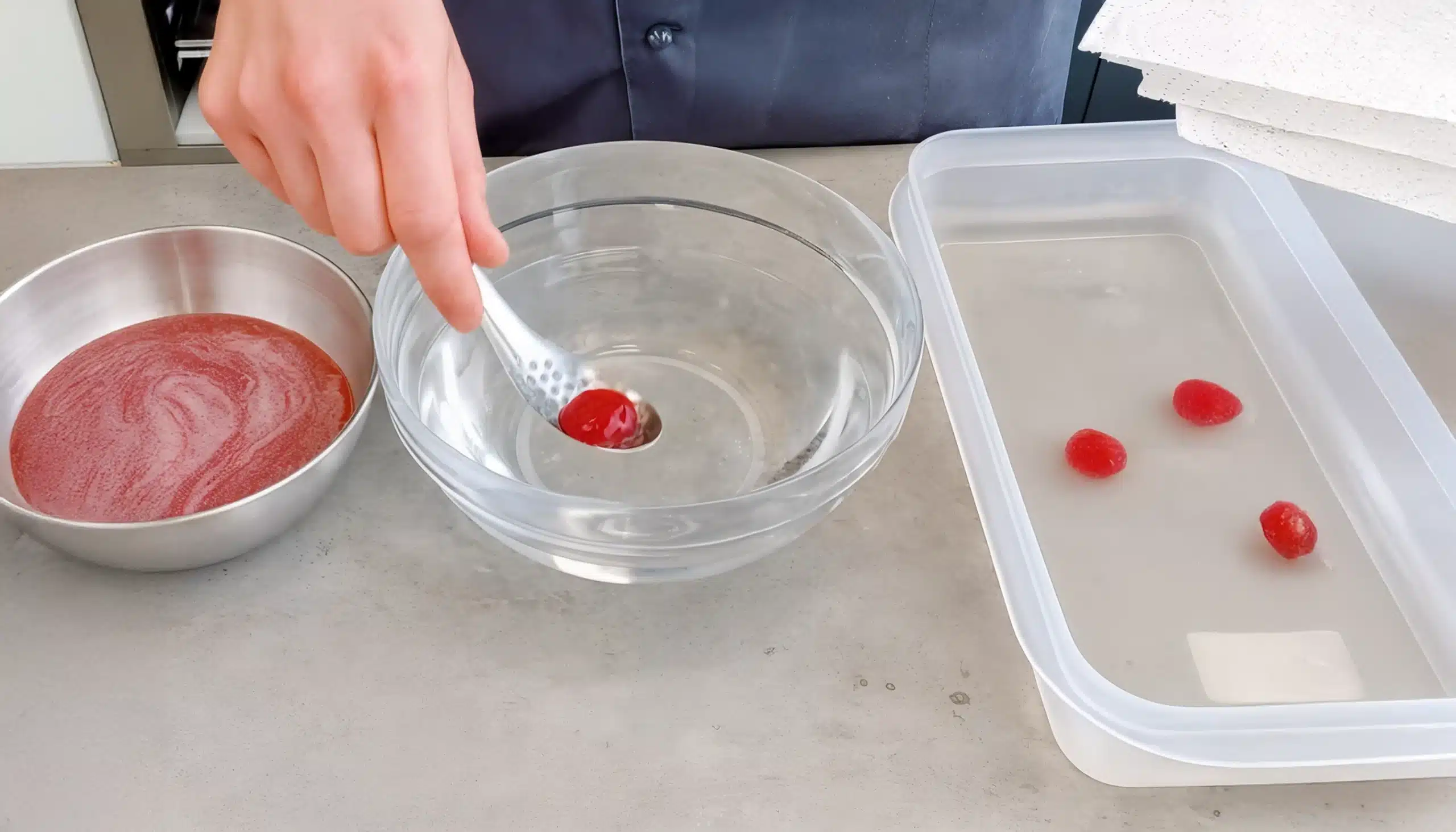un bol con agua aclarando esferificaciones de cocina molecular
