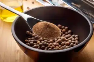 pimienta de jamaica en polvo y bayas de pimienta en un bol