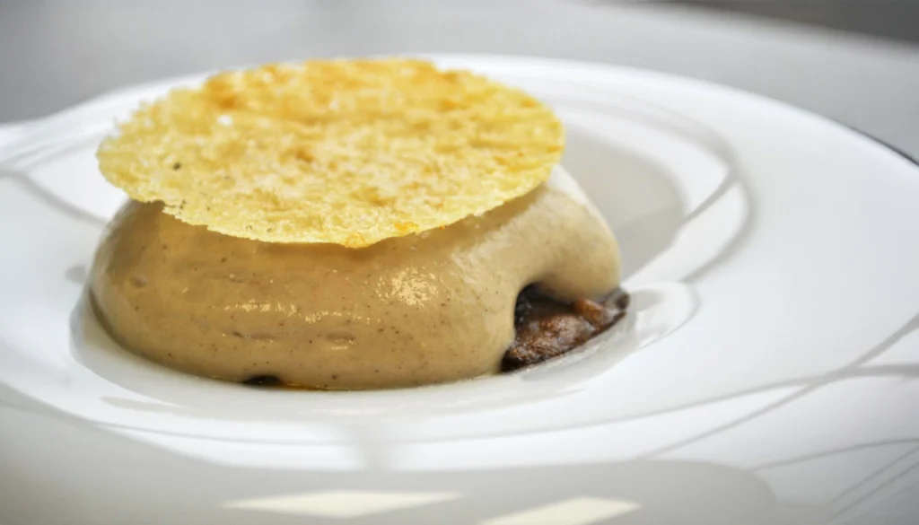 Timbal de hongos, huevo y parmesano, un plato con espuma caliente y un crujiente de queso parmesano