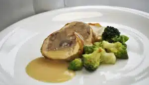 Un plato con Pollo coquelet relleno de carne con pasas