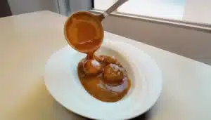 un plato de albondigas con salsa demi glace
