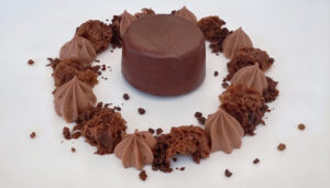 Volcán de chocolate negro acompañado de mousse de chocolate y bizcocho de chocolate