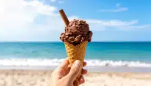 un cucurucho con helado de chocolate con una rama de canela