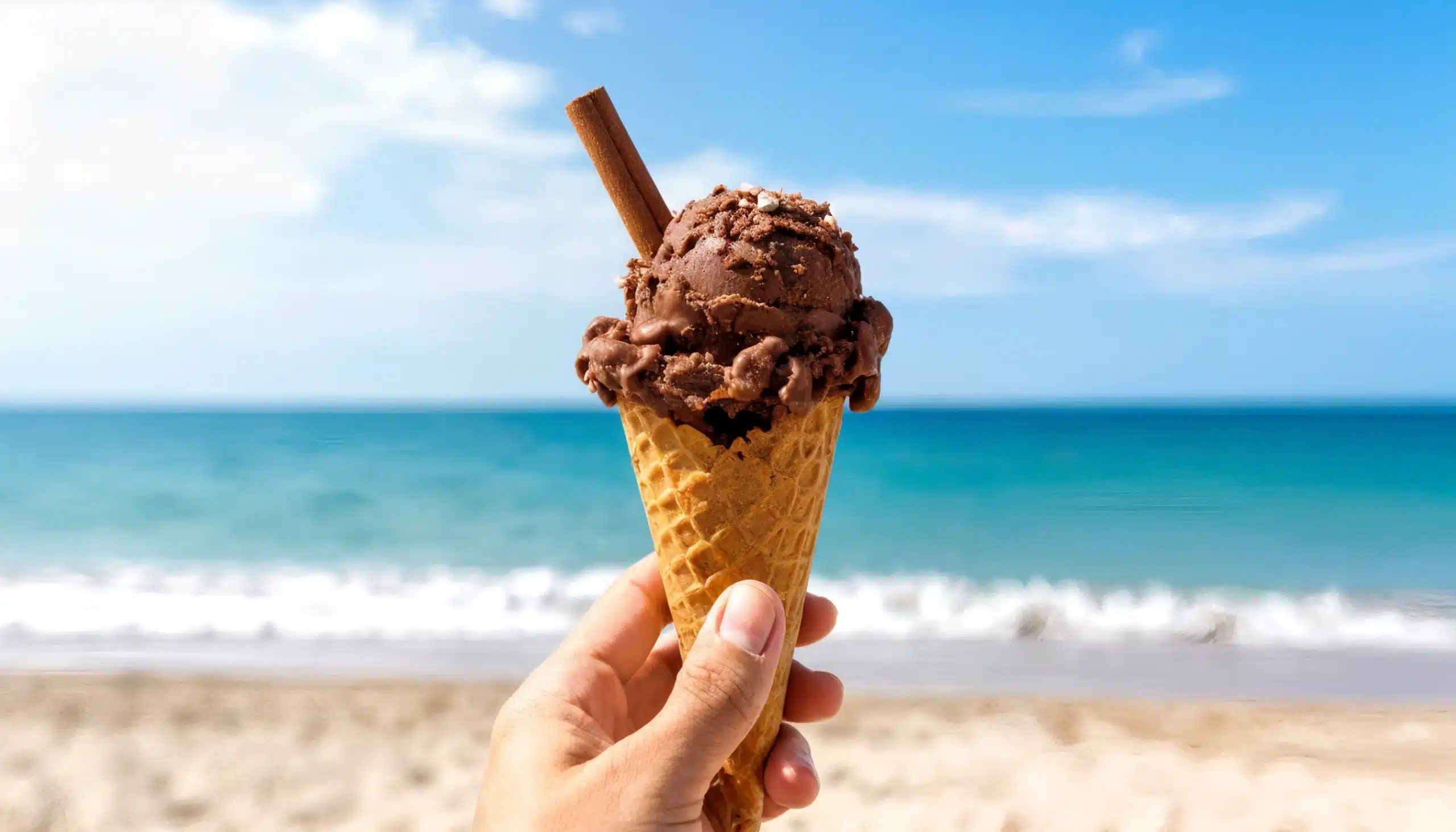 un cucurucho con helado de chocolate con una rama de canela