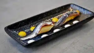 anchoas cocinadas con sal viva sobre esparragos aliñados con una vinagreta de nísperos y yogurt griego