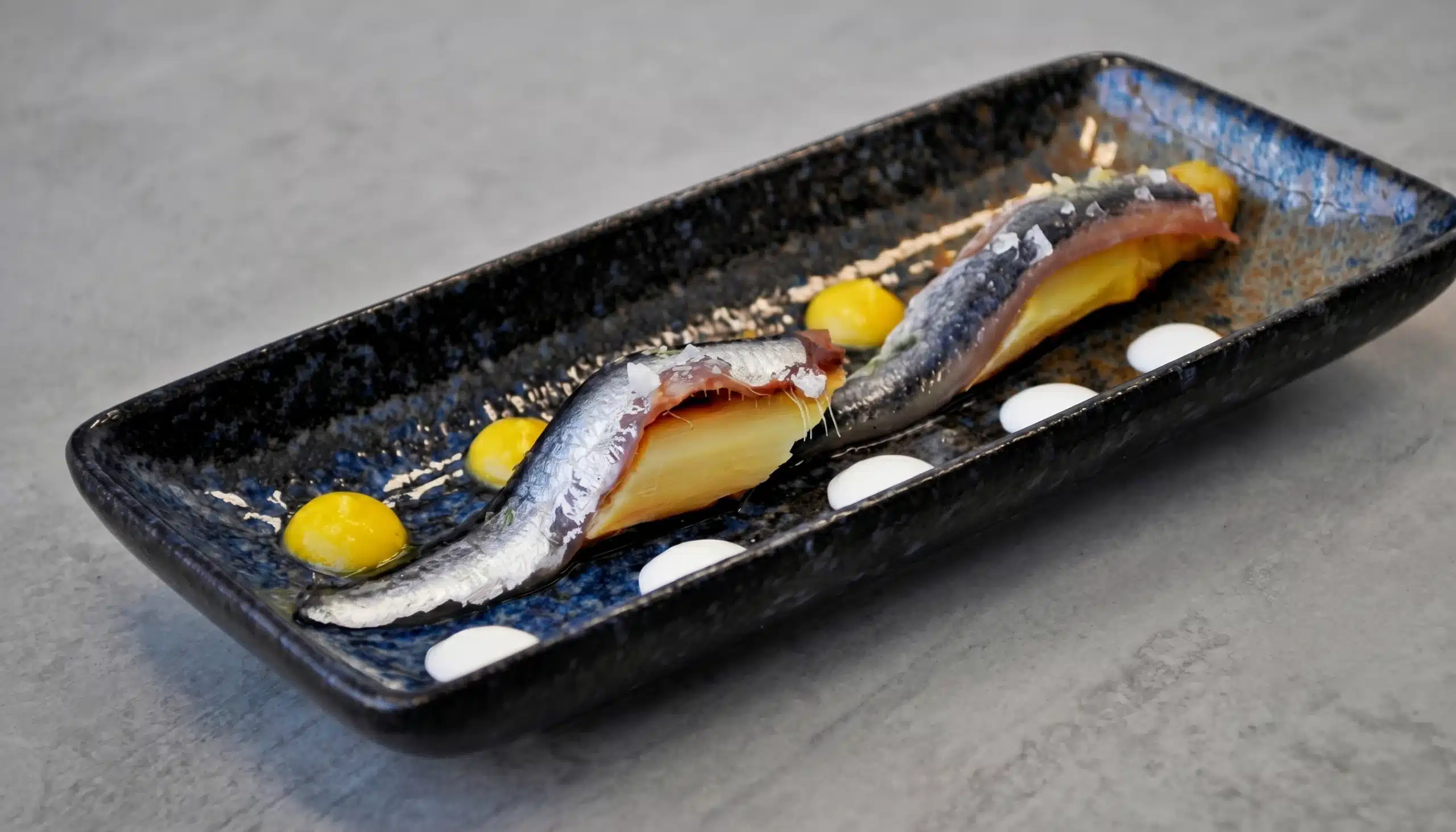 anchoas cocinadas con sal viva sobre esparragos aliñados con una vinagreta de nísperos y yogurt griego