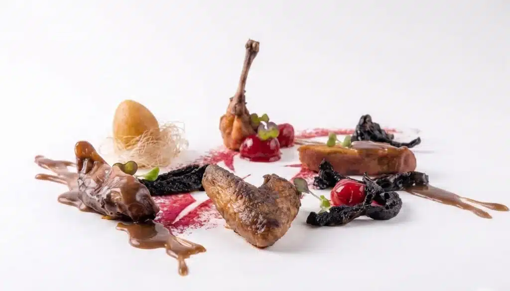 plato de despiece de pichón con nido de sus interiores y frambuesa glaseada en regaliz, explicando la técnica de glaseado