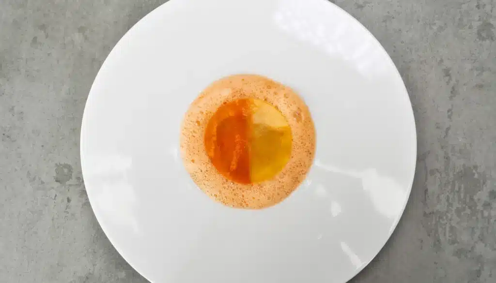 un plato de tartar de gambas y mango con gelatina de dos colores y aire de gamba